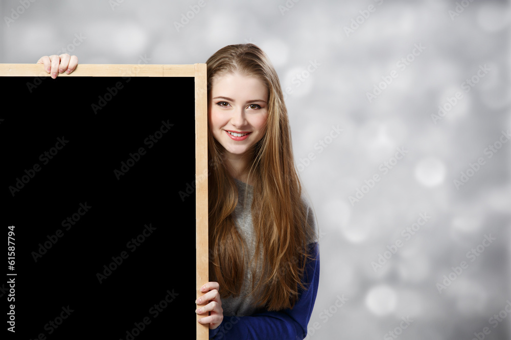 student female holding a chalkboard at light background student female holding a chalkboard at light background