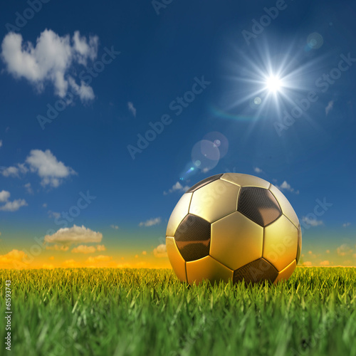 Goldener Fussball vor brasilinisch farbener Umgebung