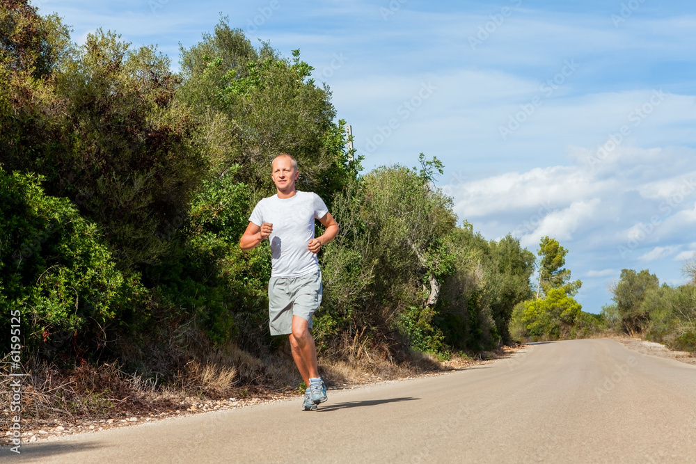 Junger sportlicher mann beim rennen joggen im sommer Junger sportlicher mann beim rennen joggen im sommer