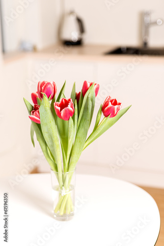 tulips bouquet in glass on kitchen table