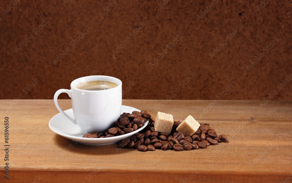 Obraz premium Coffee cup on saucer, beans and sugar on a wooden table