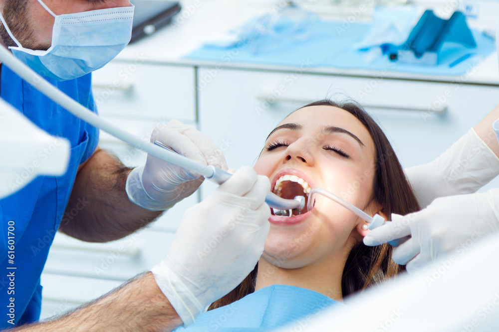 Fototapeta premium Cute young woman at the dentist. Mouth checkup