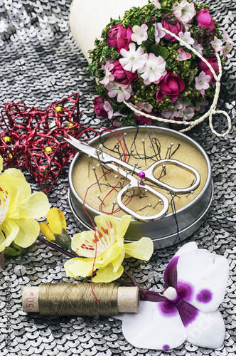 composition with sewing tools and floral decorations