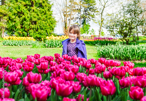 Spring portrait of adorable little girl with pink tulips
