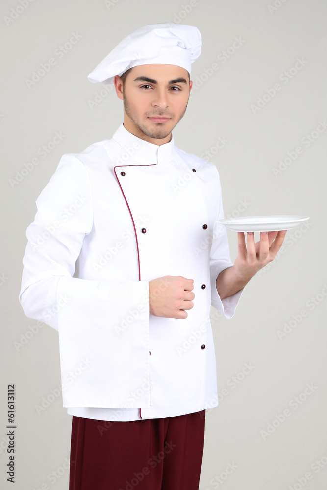Professional chef in white uniform and hat, on gray background Professional chef in white uniform and hat, on gray background