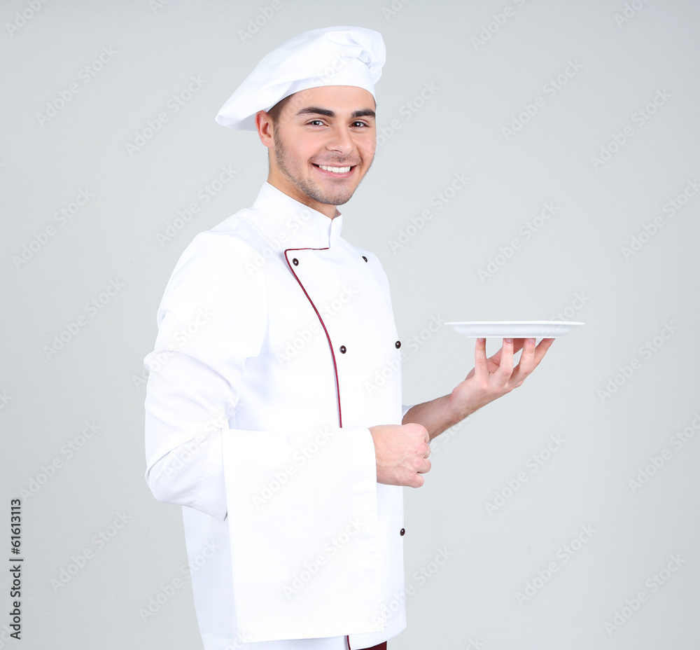 Professional chef in white uniform and hat, on gray background Professional chef in white uniform and hat, on gray background