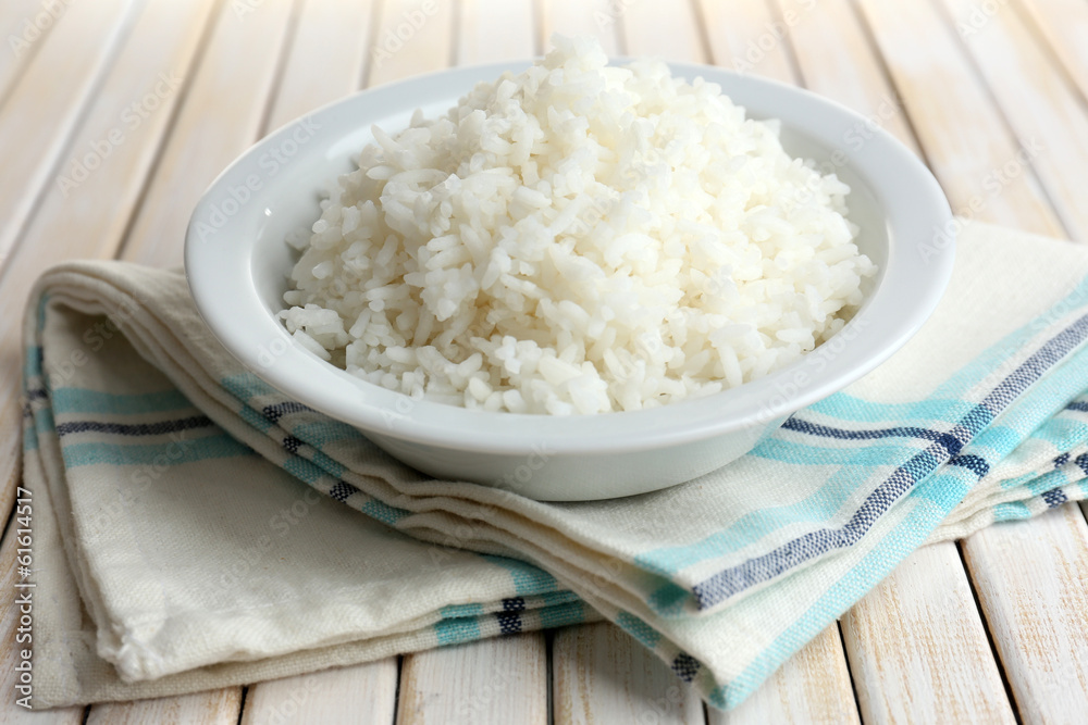 Cooked rice in bowl on wooden background Cooked rice in bowl on wooden background