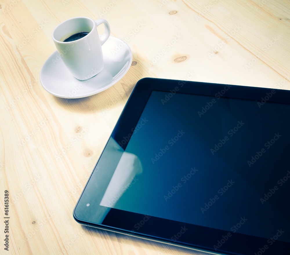 cup of coffee near a tablet, concept of new technology cup of coffee near a tablet, concept of new technology