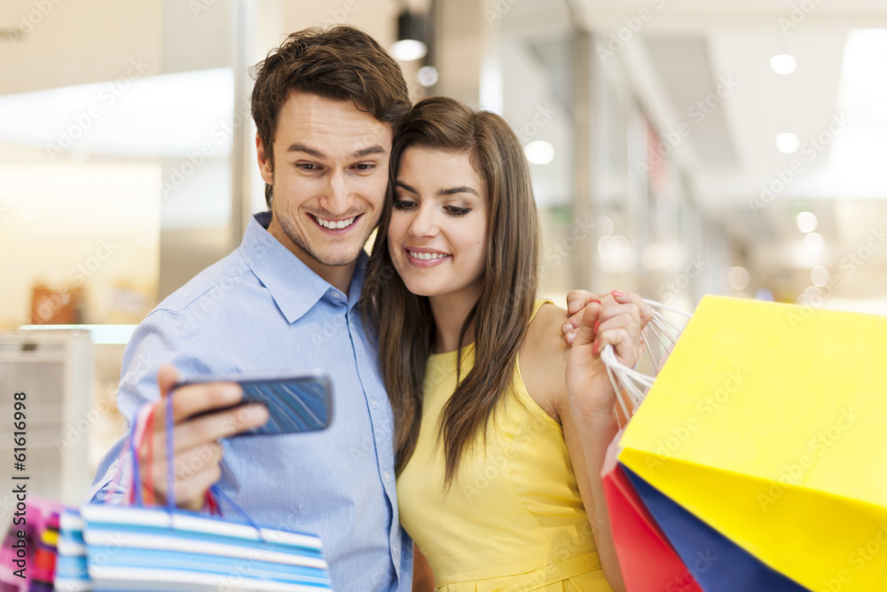 Checking something on the mobile phone during the shopping Checking something on the mobile phone during the shopping