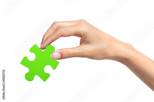 Green puzzle with woman hand isolated on white background