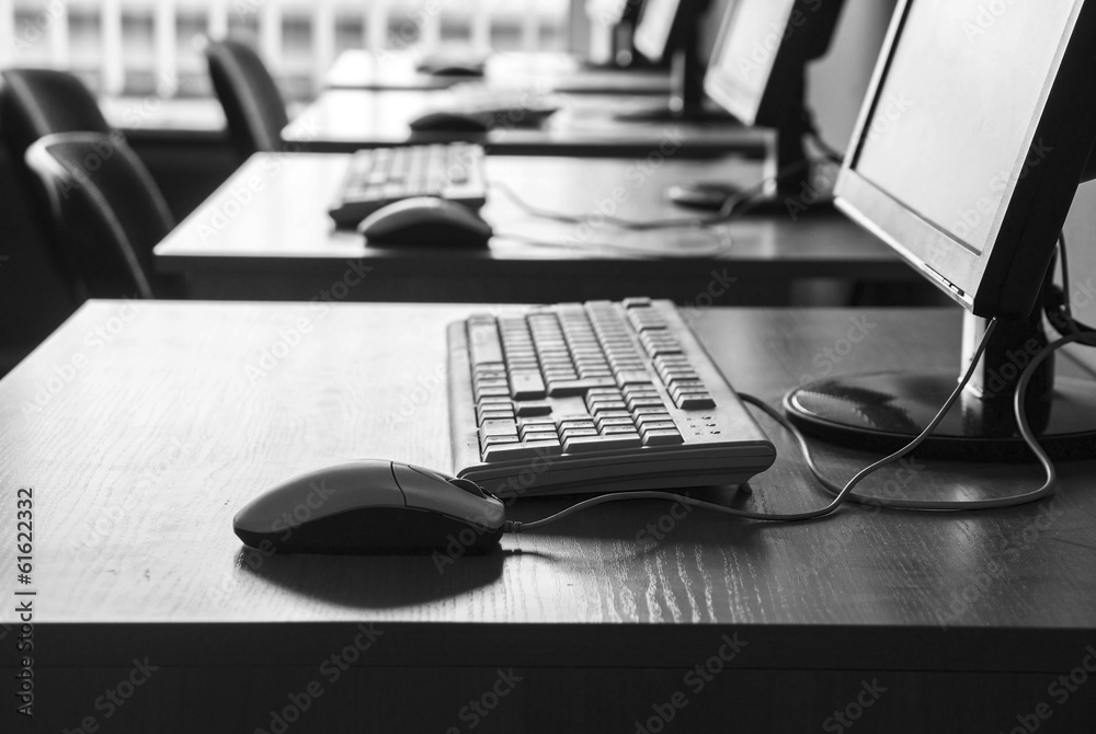 Row of workplaces with computers in office in black and white Row of workplaces with computers in office in black and white