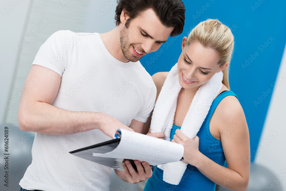 Fototapeta premium trainer bespricht fitnessplan mit kundin