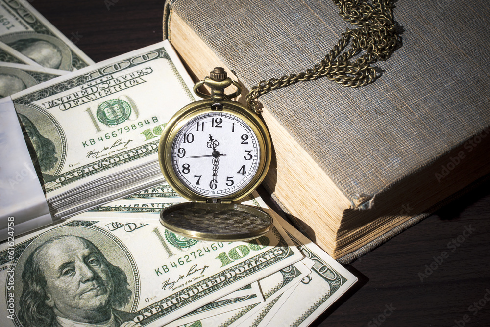 Still life of pocket watch on bills and old book Still life of pocket watch on bills and old book
