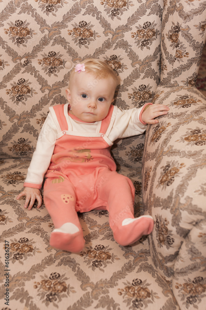 Fototapeta premium portrait of toddler girl sitting on armchair