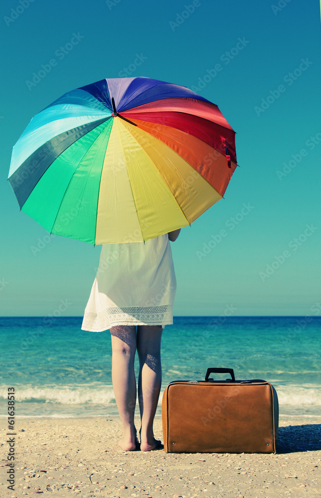 Summer vacation concept: beautiful model holding umbrella and po