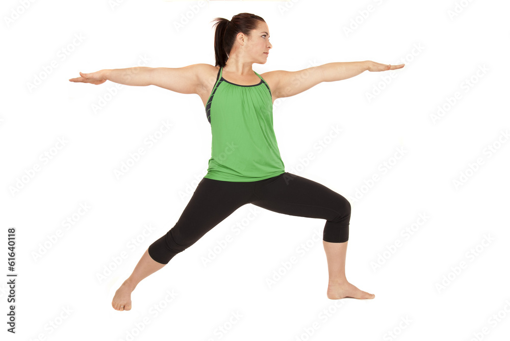 Woman doing yoga pose called warrior 2 arms out Woman doing yoga pose called warrior 2 arms out