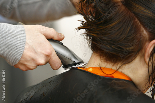 Woman having a haircut with a hair machine clippers