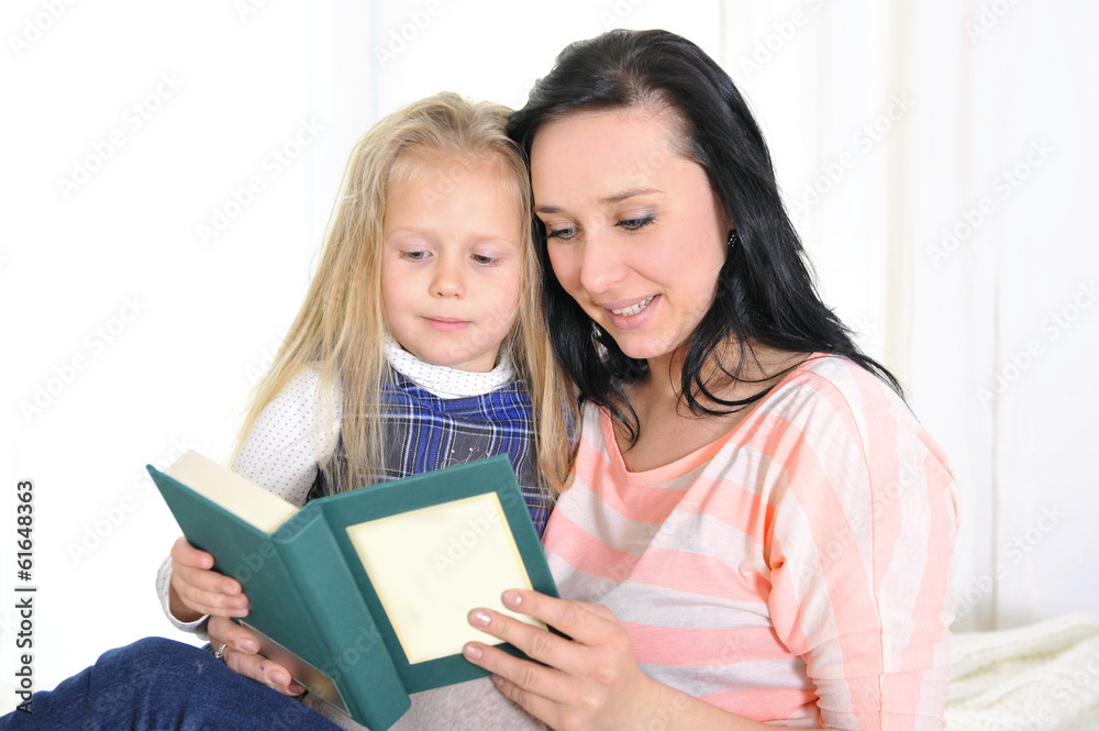 attractive woman with beautiful daughter reading book attractive woman with beautiful daughter reading book