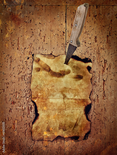 Paper pinned with a knife to the old wooden wall