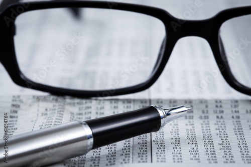 closeup glasses on financial newspaper