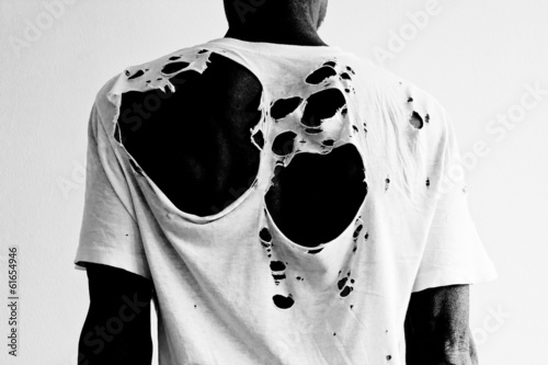 man's back with a ripped t-shirt
