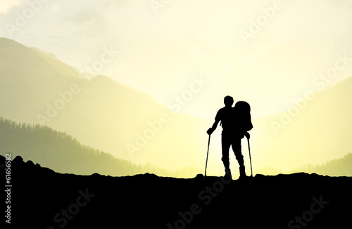 Silhouette of tourist in mountains. Sport and active life photo