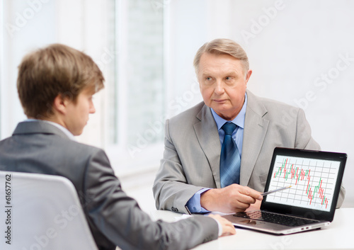 older man and young man with laptop computer