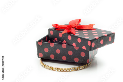 Gift box and gold bracelet in white background