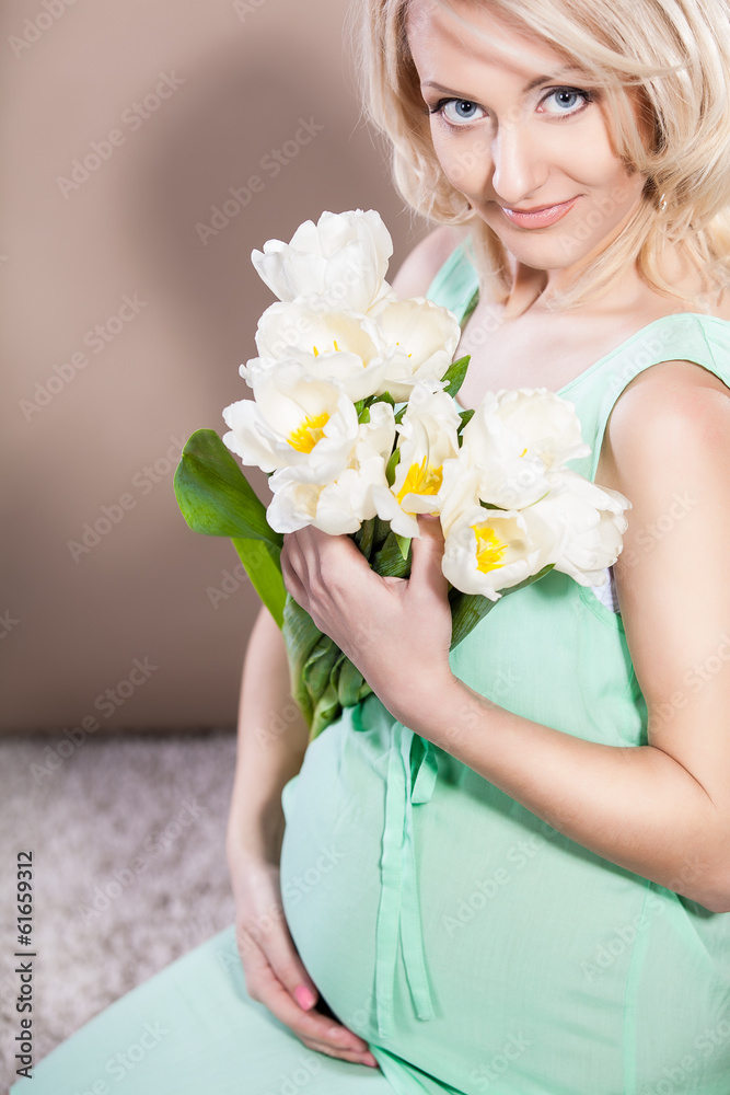 Pregnant woman holding in hands bouquet of flowers Pregnant woman holding in hands bouquet of flowers