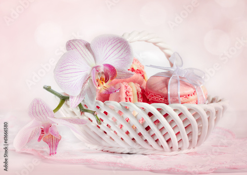 French macarons with orchid on pink background background.