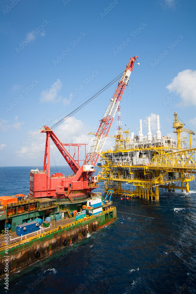 Fototapeta premium Large crane vessel installing the platform in offshore