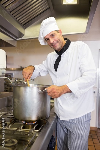 Smiling male chef preparing food in kitchen