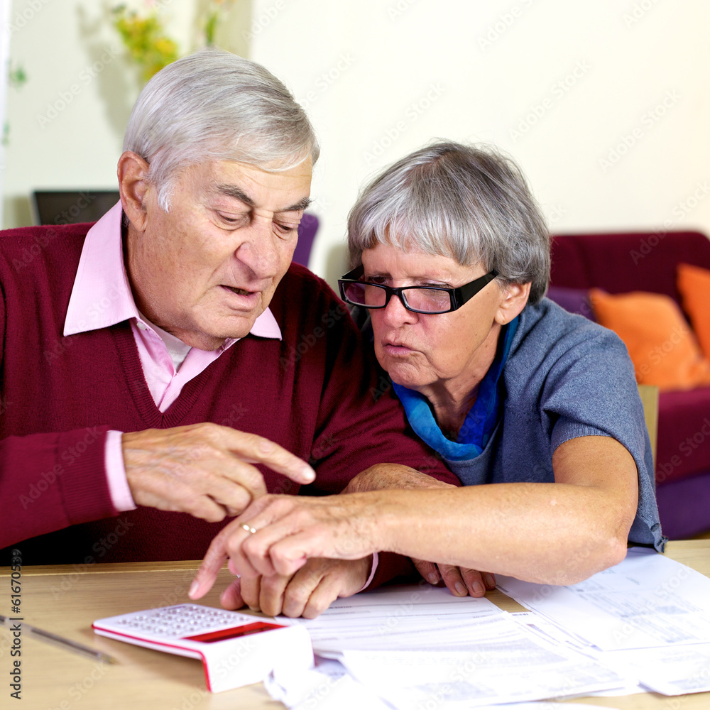 Elderly couple working with documents and taxes Elderly couple working with documents and taxes