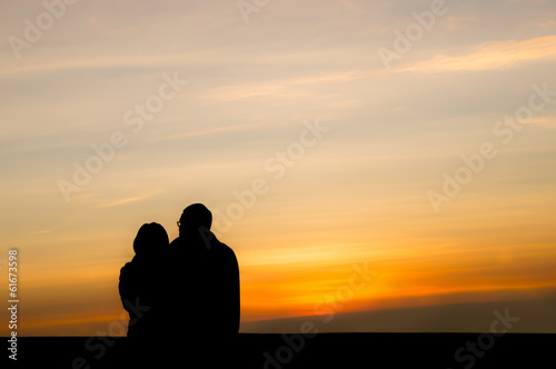 silhouette of lovers waiting for sunrise.