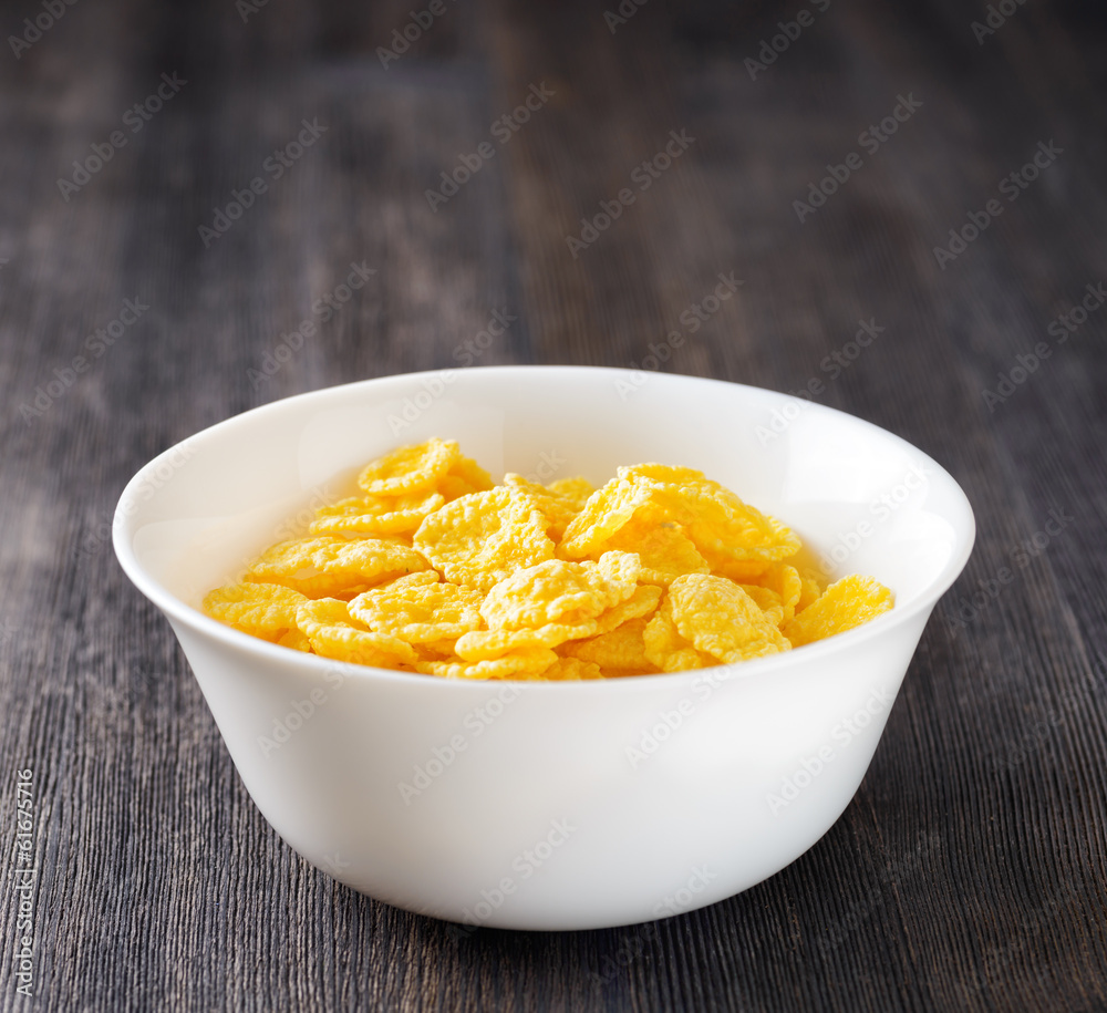 Bowl of cornflakes on wooden table Bowl of cornflakes on wooden table