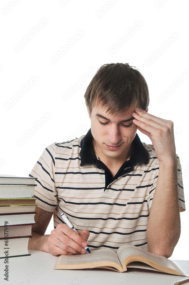 Male student at the table with pile of books Male student at the table with pile of books