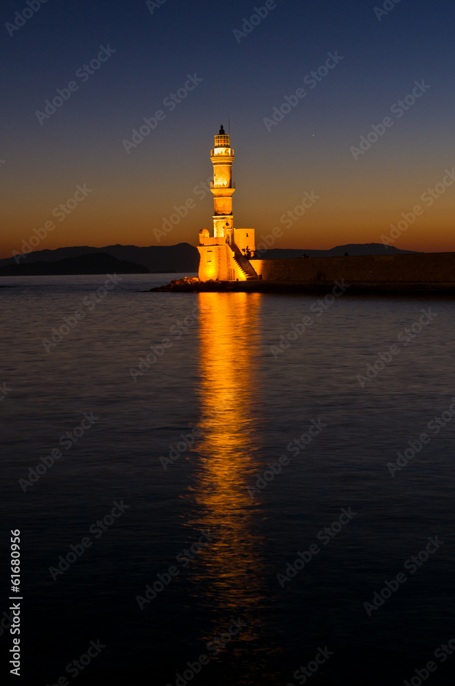 View of entrance to harbor with lighthouse at sunset, Crete