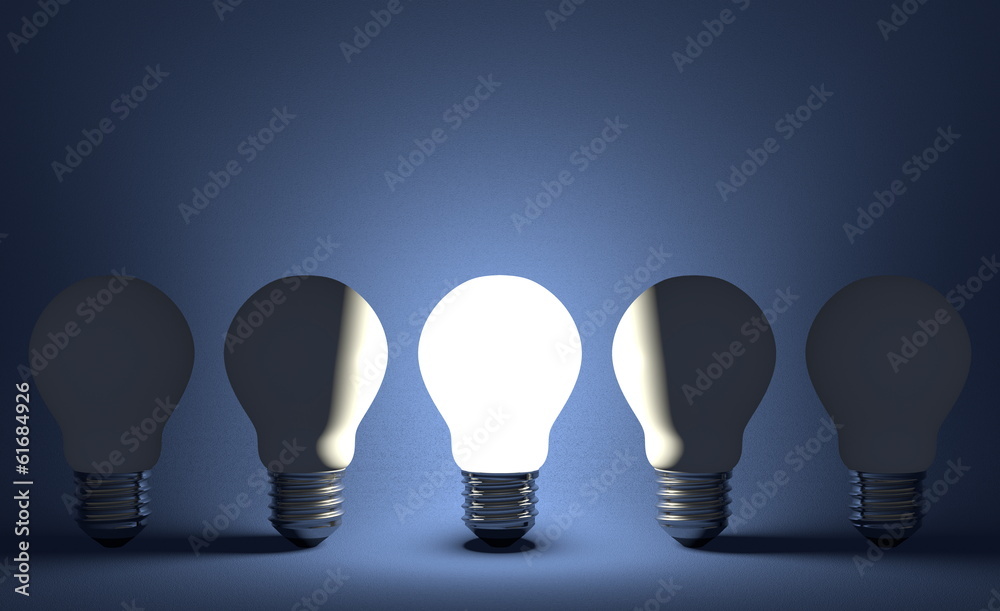 Glowing light bulb in row of switched off ones on blue Glowing light bulb in row of switched off ones on blue