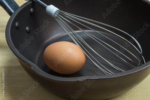 Tableau sur toile Egg whist and pan on wood