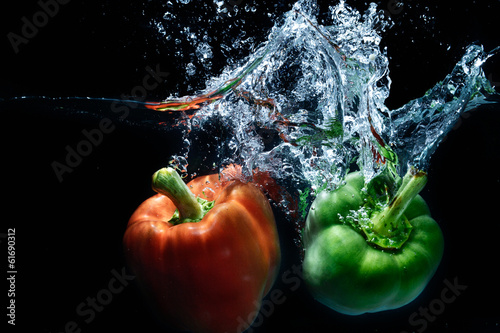 sweet pepper drop into water on black background.
