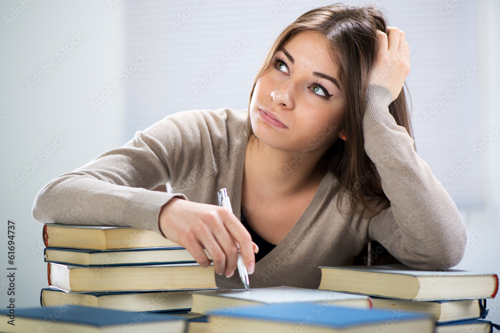 Tired student sitting with many books Tired student sitting with many books