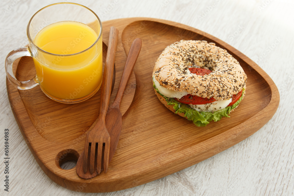 A sesame sandwich bun and a glass of juice A sesame sandwich bun and a glass of juice