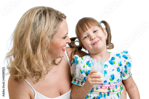 Kid drinking milk. Mother looks to daughter.
