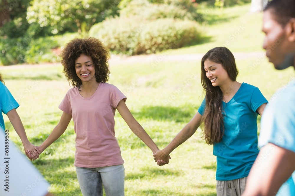 Fototapeta premium Friends holding hands in circle at park