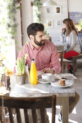 Modern young man sitting in coffee shop