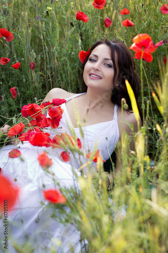 Portrait of the beautiful girl in a poppy field
