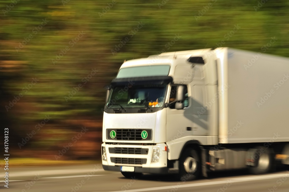 Fast moving white truck, motion blur