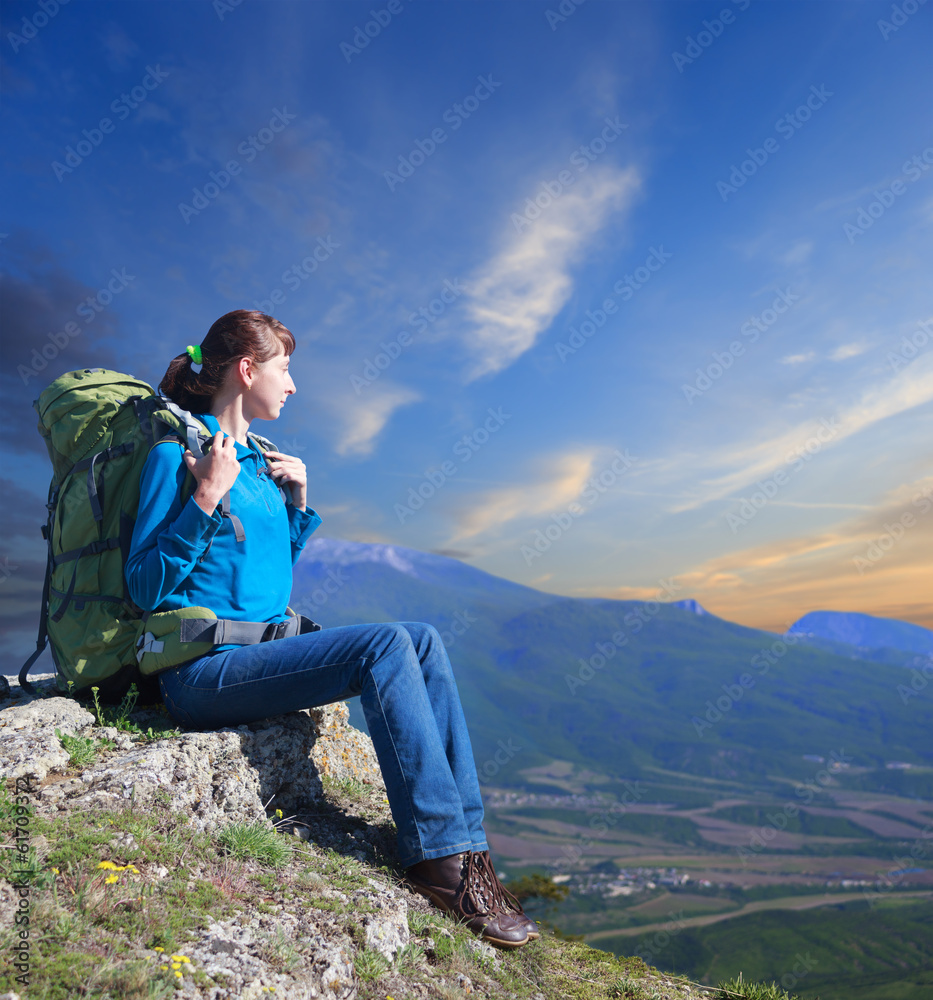 Woman with backpack enjoying sunset on top of mountain Woman with backpack enjoying sunset on top of mountain