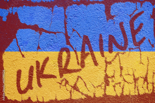 Ukraine flag painted on old concrete wall with UKRAINE inscripti
