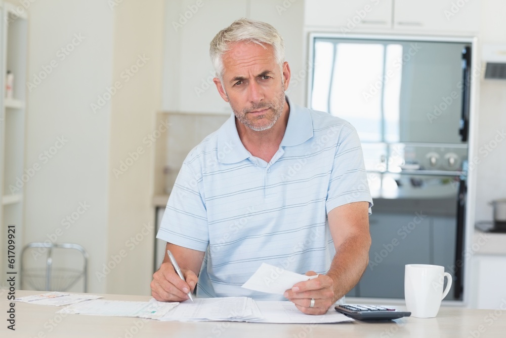 Serious man working out his finances Serious man working out his finances